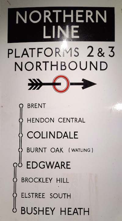 A platform sign containing a Northern Line diagram. It's typeset in a humanist sans-serif font. It reads: "Northern Line, platforms 2 & 3 Northbound", followed by an illustration of an arrow striking through an early prototype of the London Underground roundel. Below reads the stations: Brent, Hendon Central, Colindale, Burnt Oak (Watling), Edgware, where one line terminates and another begins. This line goes: Edgware, Brockley Hill, Elstree South, Bushey Heath.